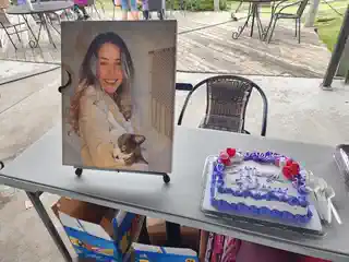 Portrait of Shannan Hickey displayed beside a memorial cake