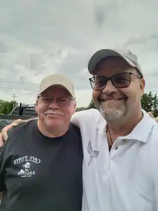 Two friends posing together at the memorial golf tournament