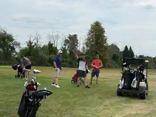 Golfers gathered with carts on the course