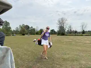 Golfer walking across the course with a golf bag