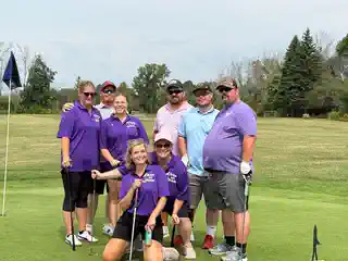 Tournament group posing together on the green