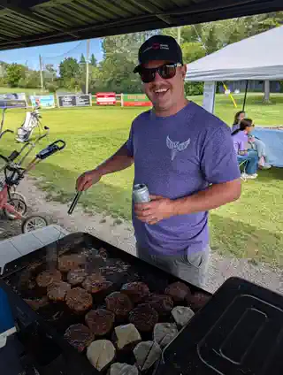 Volunteer grilling burgers during tournament day